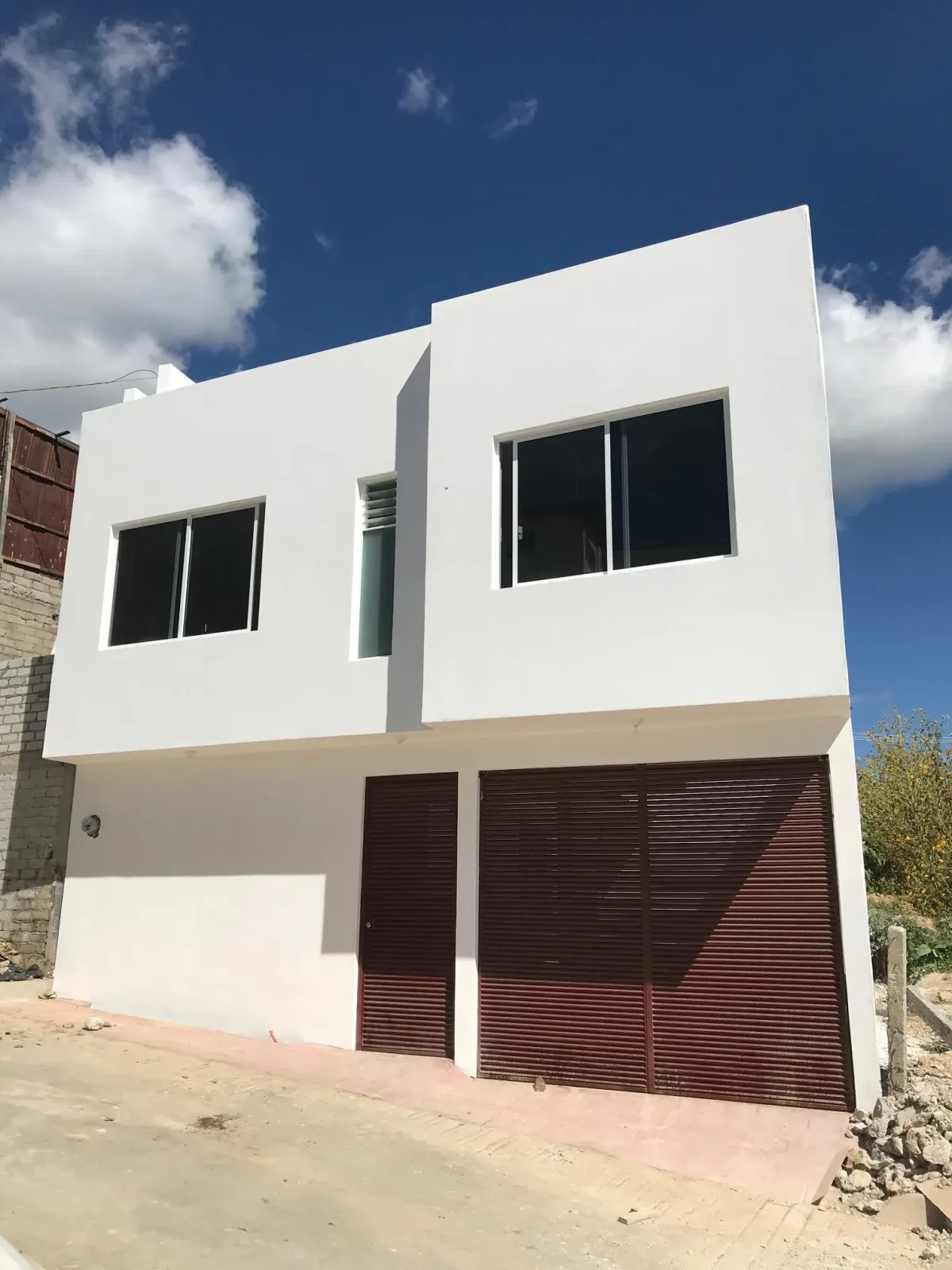 Casa de dos plantas con portones de lamas de madera