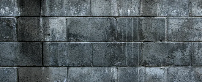 Muro de block de concreto gris visto de frente, con las hiladas y las juntas a la vista